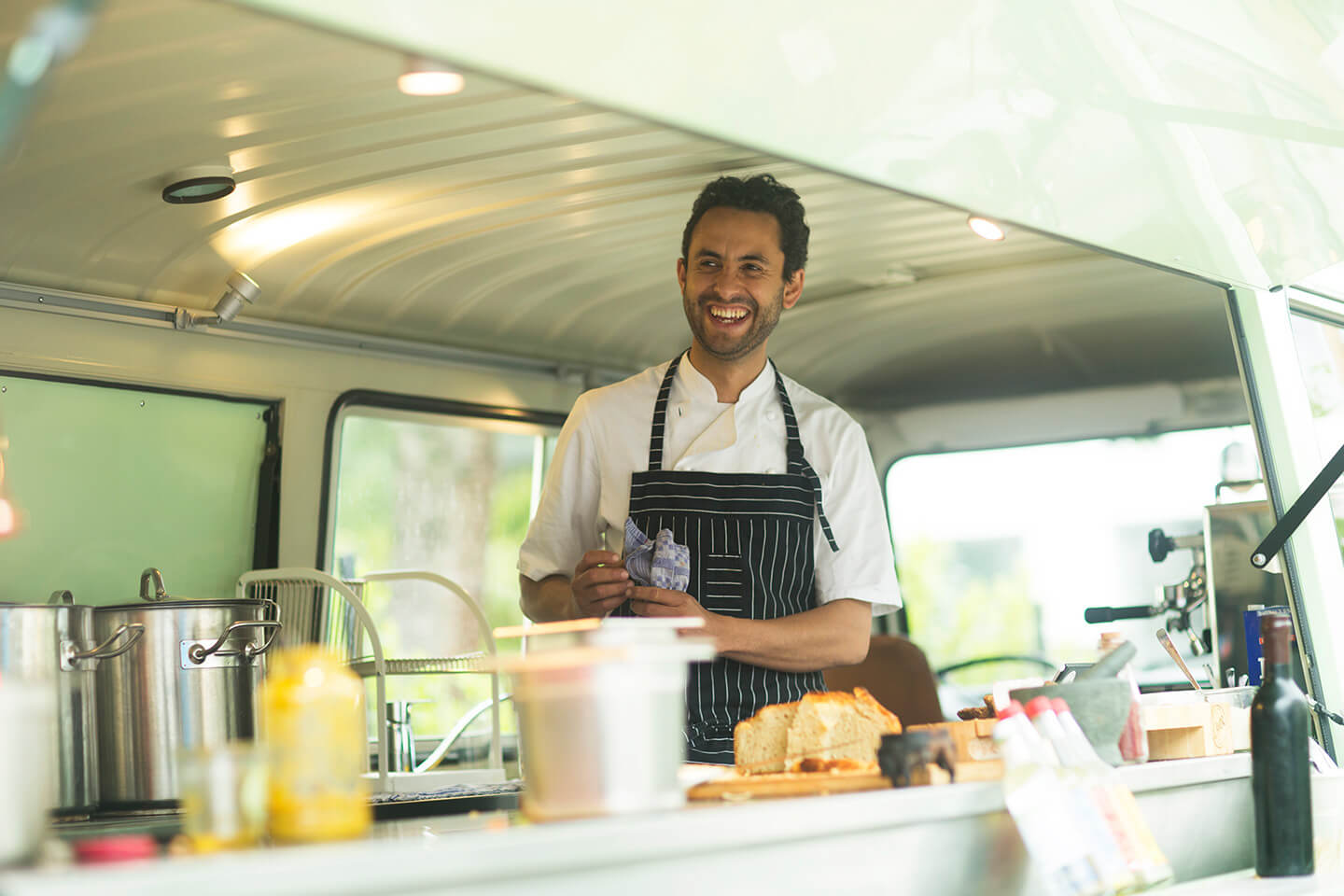 A man happily works at his food truck.